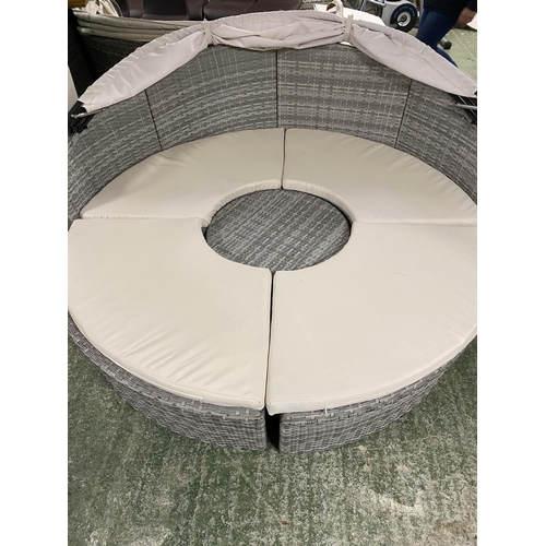 505 - GARDEN FURNITURE: Two similar grey faux rattan/all weather semi circular garden sun sofas and cream ... 