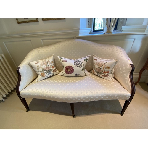 560 - A good show framed settee, upholstered in cream silk fabric, raised on tapered legs to brass drum ca... 