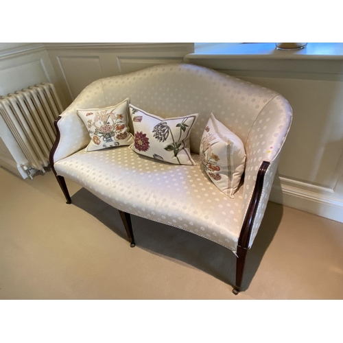 560 - A good show framed settee, upholstered in cream silk fabric, raised on tapered legs to brass drum ca... 