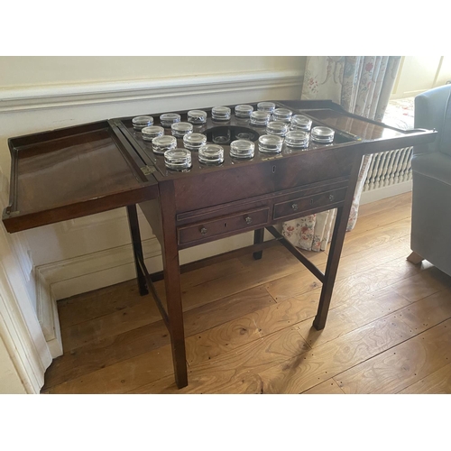 571 - A Georgian figured mahogany fold over top table, revealing 12 fitted glasses, surrounding a central ... 