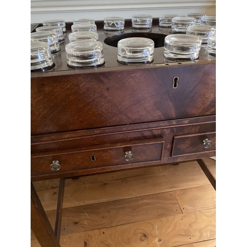 571 - A Georgian figured mahogany fold over top table, revealing 12 fitted glasses, surrounding a central ... 