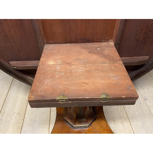 614 - A good Regency mahogany and rosewood circular snap top dining table, with brass edgings, on an octag... 