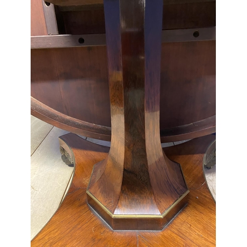 614 - A good Regency mahogany and rosewood circular snap top dining table, with brass edgings, on an octag... 