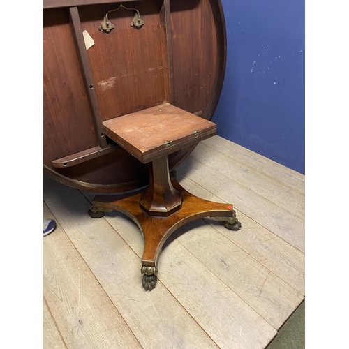 614 - A good Regency mahogany and rosewood circular snap top dining table, with brass edgings, on an octag... 