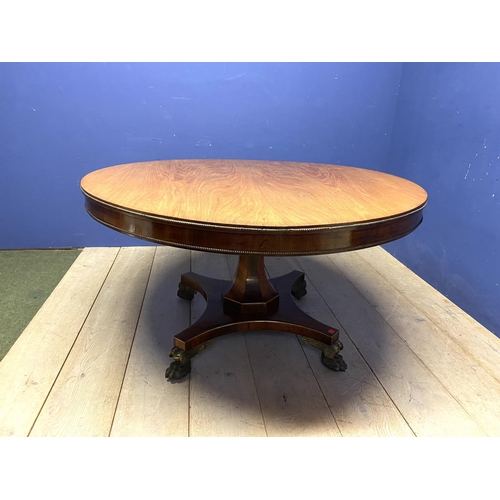 614 - A good Regency mahogany and rosewood circular snap top dining table, with brass edgings, on an octag... 