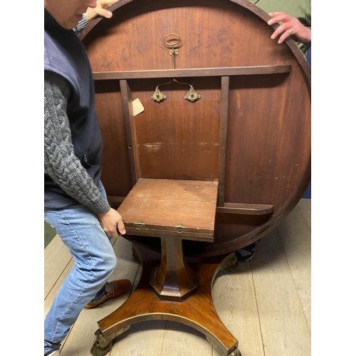 614 - A good Regency mahogany and rosewood circular snap top dining table, with brass edgings, on an octag... 