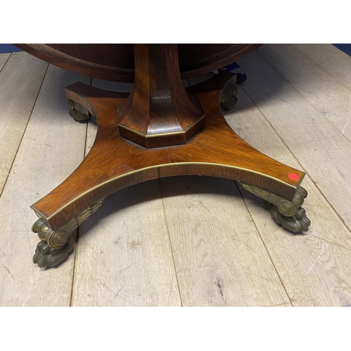 614 - A good Regency mahogany and rosewood circular snap top dining table, with brass edgings, on an octag... 