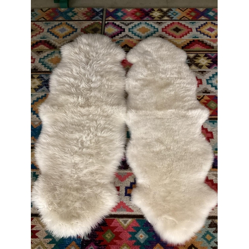 693 - Two 100% sheepskin rugs, 170 x 60cm