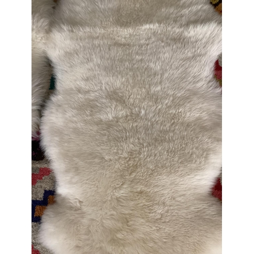 693 - Two 100% sheepskin rugs, 170 x 60cm