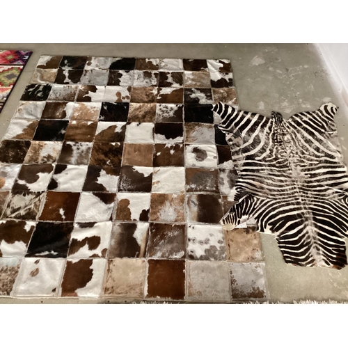 695 - Two rugs: zebra 130x198cm slightly worn, not backed cowhide patchwork rug 202cm x 163cm worn in plac... 