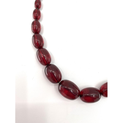 82 - A string of cherry amber graduated beads with additional beads, 106g, 70cm