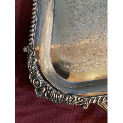 92 - A large oblong silver plated tray, cast border, chased decoration with loop handles 69 cm x  41 cm, ... 