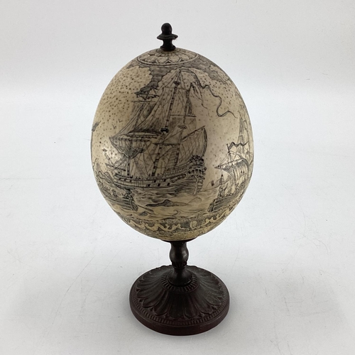 176 - An Ostrich egg on cast bronzed mounts and nautical scene 23cmH