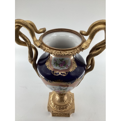 249 - Meissen style lidded urn with gilt brass base and finial, gilt brass entwined snake handles, hand pa... 