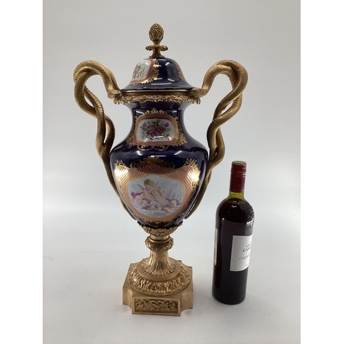 249 - Meissen style lidded urn with gilt brass base and finial, gilt brass entwined snake handles, hand pa... 