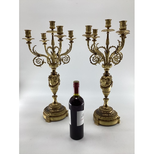 258 - Pair of C19th gilt brass five branch table candelabras, on circular stepped bases, with goats head d... 