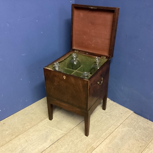 312 - A mahogany square and fitted decanter box on raised legs, with brass handles to each side, as found