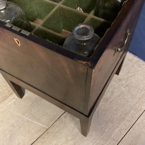 312 - A mahogany square and fitted decanter box on raised legs, with brass handles to each side, as found