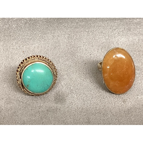 33 - Two unmarked yellow metal poison rings, one set with amber, and one with turquoise cabochon, each op... 