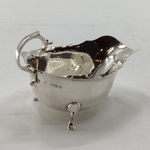 45 - A collection of sterling silver items to include toast rack, sauce boat, and other items