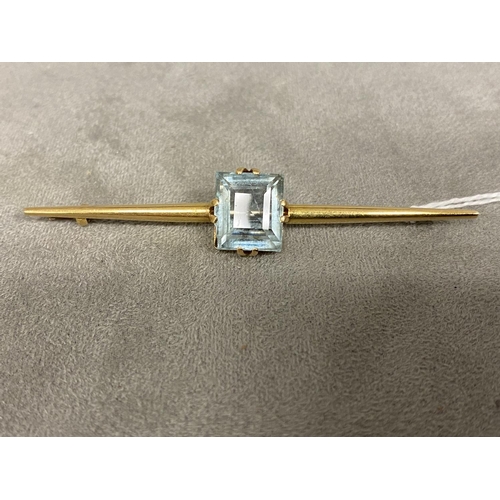 6 - An unmarked yellow metal bar brooch, set with single emerald cut aquarmarine (12mm x 12mm) 7.8 g