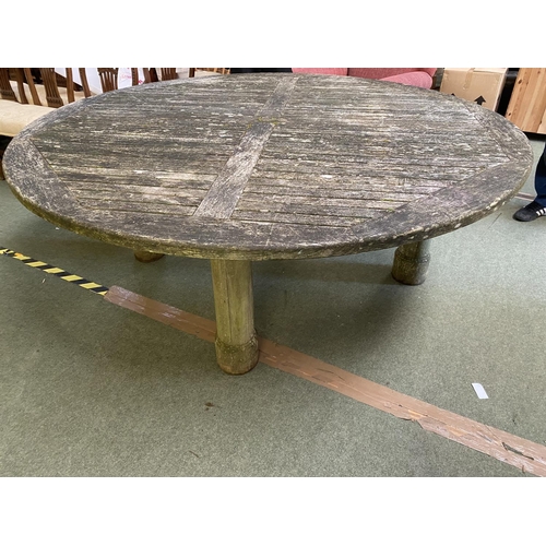 339 - A large circular weathered garden table, 200cmD (one leg loose)