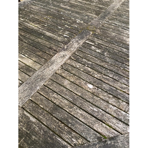 339 - A large circular weathered garden table, 200cmD (one leg loose)