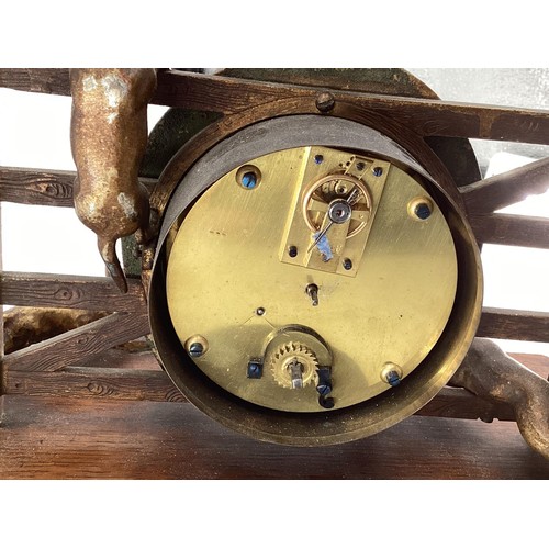 307 - A desk clock, depicting model of Fox and Hounds at a farm gate, 28cm Wide, on a wooden plynth