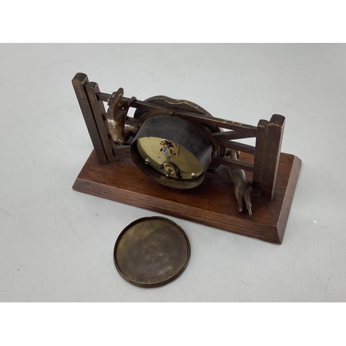 307 - A desk clock, depicting model of Fox and Hounds at a farm gate, 28cm Wide, on a wooden plynth