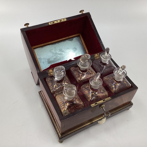 107 - A Victorian mahogany six bottle decanter box with domed lid, six glass decanters with original stopp... 