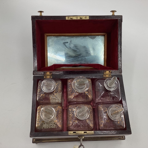 107 - A Victorian mahogany six bottle decanter box with domed lid, six glass decanters with original stopp... 