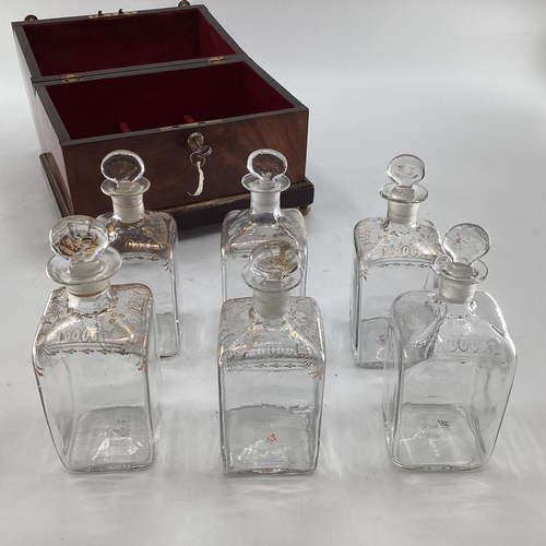 107 - A Victorian mahogany six bottle decanter box with domed lid, six glass decanters with original stopp... 