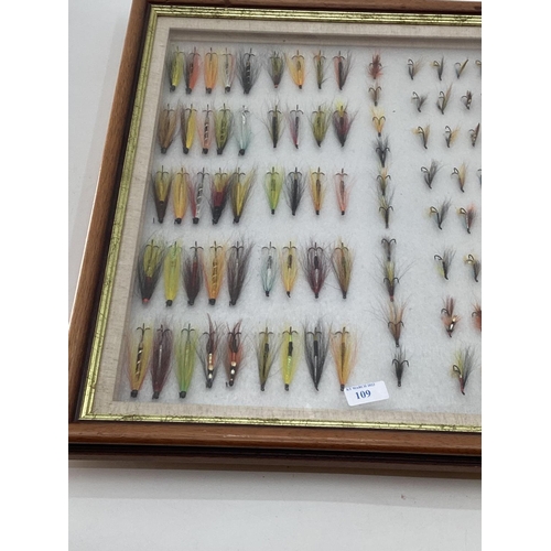 109 - A collection of fishing flies in a boxed glass display frame 58 x 67cm