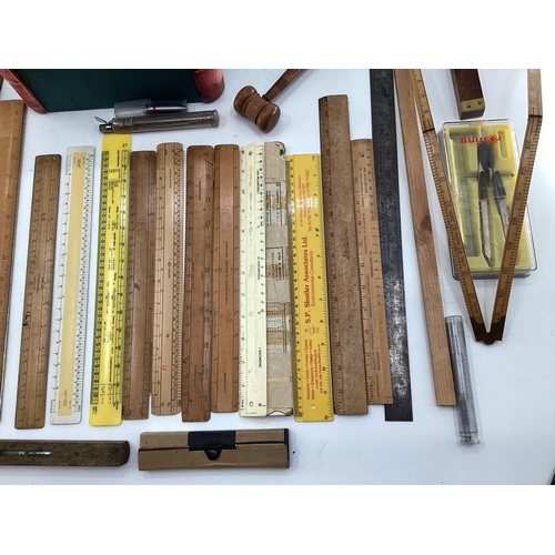 110 - A collection of measuring instruments to include Set Square, rulers etc