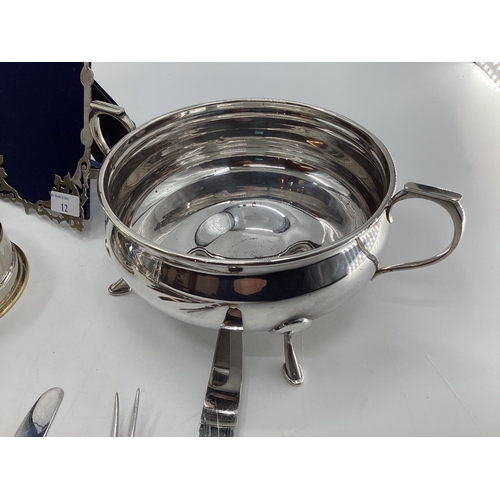 12 - Collection of electroplated and white metal items to include a pierced picture frame, cutlery and ot... 