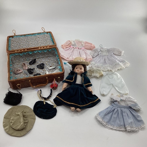 140 - Collection of dolls clothing and a porcelain doll