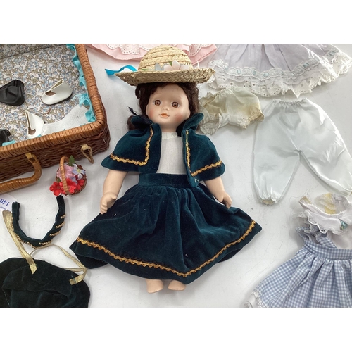 140 - Collection of dolls clothing and a porcelain doll