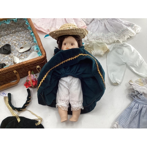 140 - Collection of dolls clothing and a porcelain doll