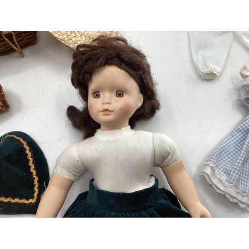 140 - Collection of dolls clothing and a porcelain doll