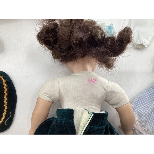 140 - Collection of dolls clothing and a porcelain doll