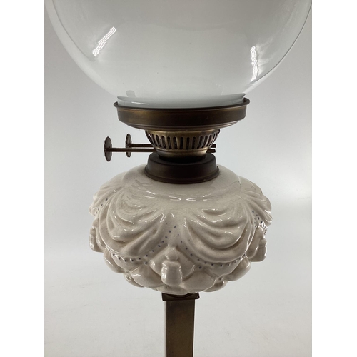 147 - A late C19th brass and glass pedestal oil lamp 66cmh