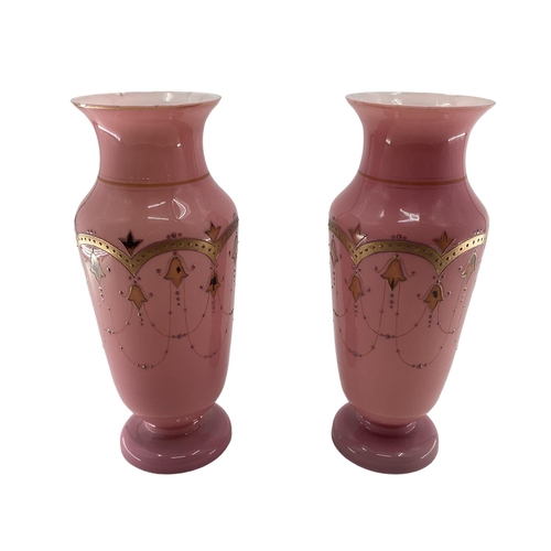 151 - Pair of early C20th pink vases with gilt decoration and circular foot 30c,