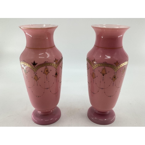 151 - Pair of early C20th pink vases with gilt decoration and circular foot 30c,