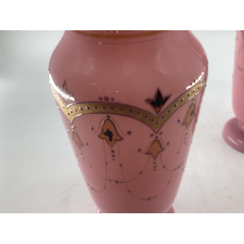 151 - Pair of early C20th pink vases with gilt decoration and circular foot 30c,