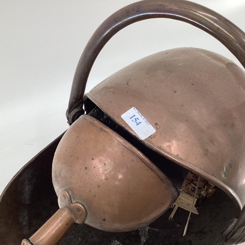 154 - A Helmet shaped copper coal scuttle