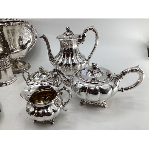 18 - A collection of silver plated wares to include a Campana style wine cooler, a 3 piece tea set and a ... 