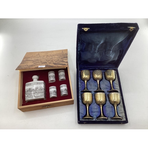 197 - A boxed set of six chased metal wine goblets together with a boxed decanter and four cups by Achen K... 