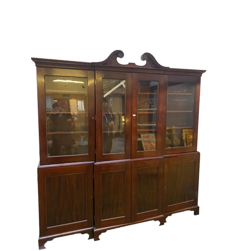 419 - A large late C19th mahogany three sectioned glazed library bookcase, the top with swan neck pediment... 