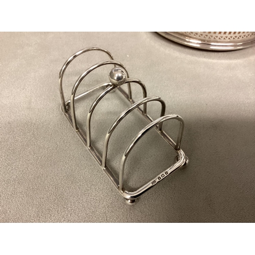 45 - A collection of sterling silver items to include scallop dish, toast rack and wine coaster