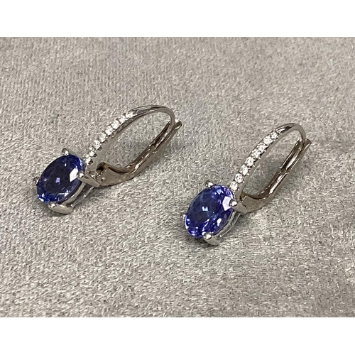 48 - A pair of unmarked white metal, Tanzanite earrings, with Bale set line of single cut diamonds (teste... 